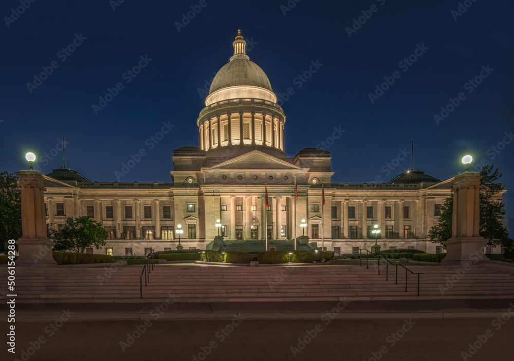 Illuminated Arkansas State Capitol at night with lights glowing from dome at night.  