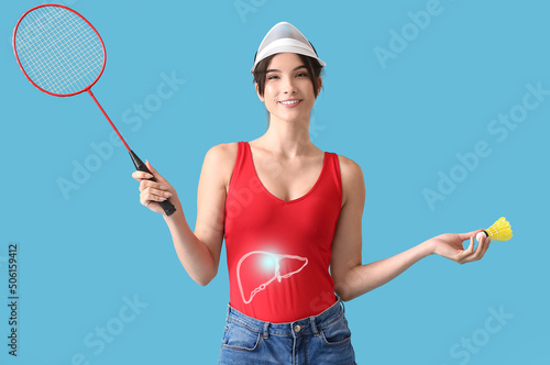 Sporty female badminton player with healthy liver on blue background © Pixel-Shot