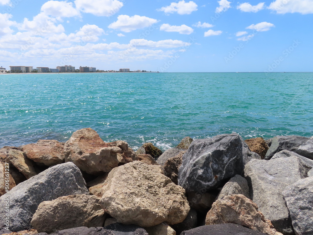 Beautiful ocean scene with rocky shore in foreground and cloudy sky in background Beautiful ocean scene with rocky shore in foreground and cloudy sky in background