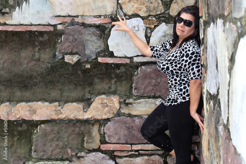 mature woman posing in the old case of Panama with a stone wall behind photo