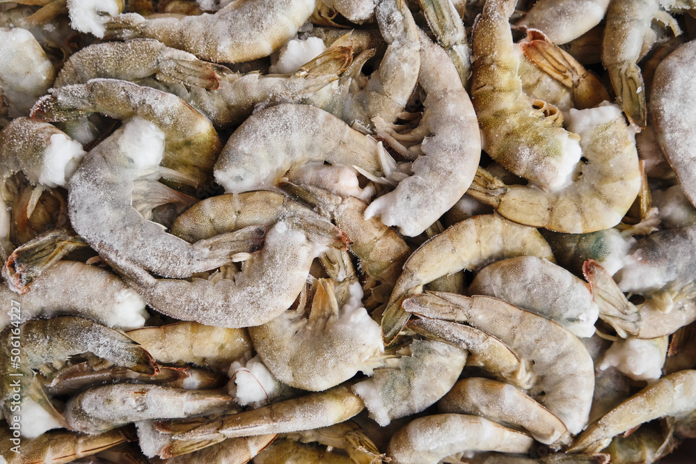 Raw frozen shrimps in a shell without head. Seafood background. Raw frozen shrimps in a shell without head. Seafood background.