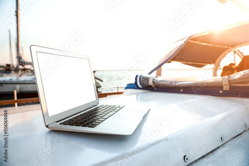 Modern laptop with blank screen on yacht