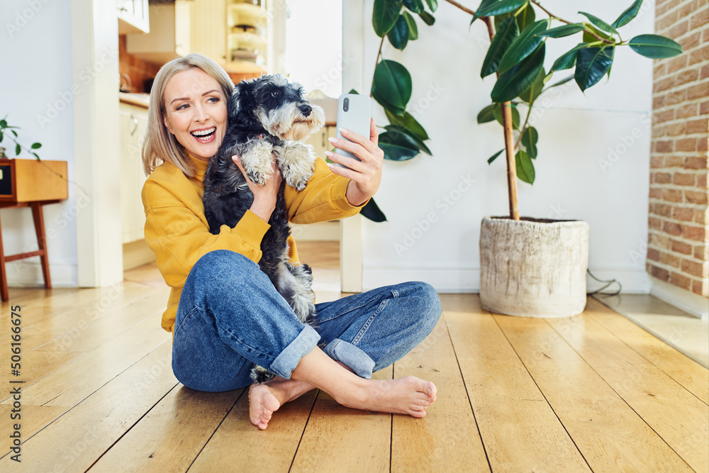 Happy middle aged woman takes selfie with dog at home Happy middle aged woman takes selfie with dog at home