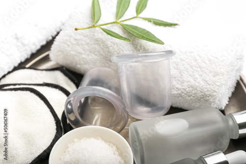 Plate with vacuum jars for anti-cellulite massage, cotton pads and towel, closeup