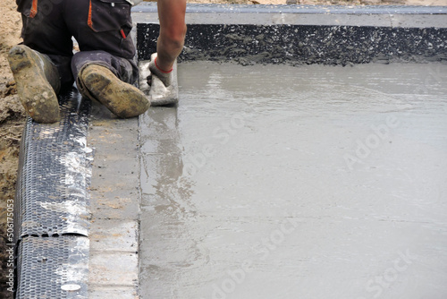 A building worker hand floating the wet concrete