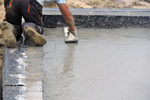 A building worker hand floating the wet concrete photo