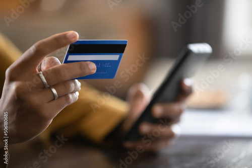 Obraz na plátně Close up cropped view African female do online shopping use credit card and smart phone
