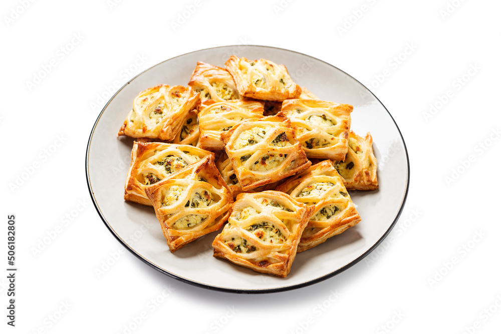 Puff pastry squares filled with feta cheese and spinach isolated on white background Puff pastry squares filled with feta cheese and spinach isolated on white background