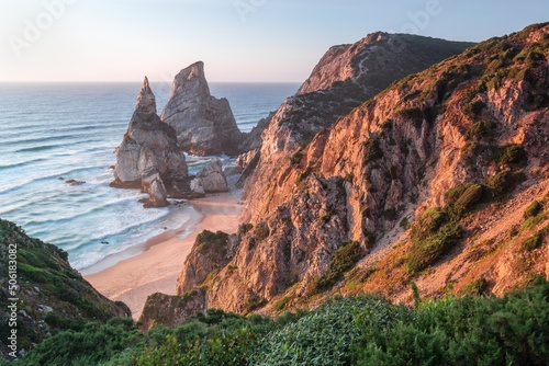 Portugal's Ursa Beach on the Atlantic coast with its cliffs and sunset waves and foam on the sand coasts a picturesque panorama of the landscape. The cliffs at Cabo da Roca.