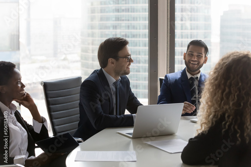 Multi ethnic company management staff participate in formal negotiations or corporate meeting. Group of young ambitions businesspeople gather in boardroom, attend in briefing. Training event concept