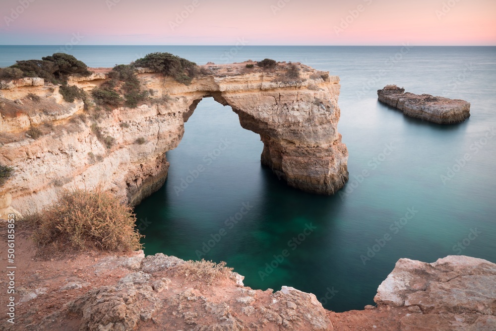 Natural arch above ocean, arco de Albandeira, Algarve, Lagoa portugal. Stone arch at beach.
Summer season.