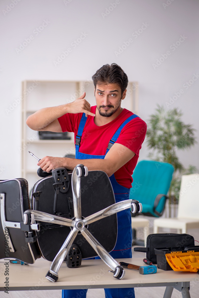 Young male repairman working at workshop Young male repairman working at workshop