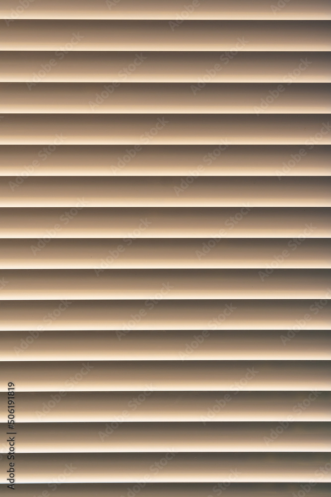 Closed window blinds illuminated by the sun, background texture Closed window blinds illuminated by the sun, background texture