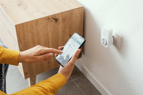 Schilderij op canvas Woman setting a smart plug at home