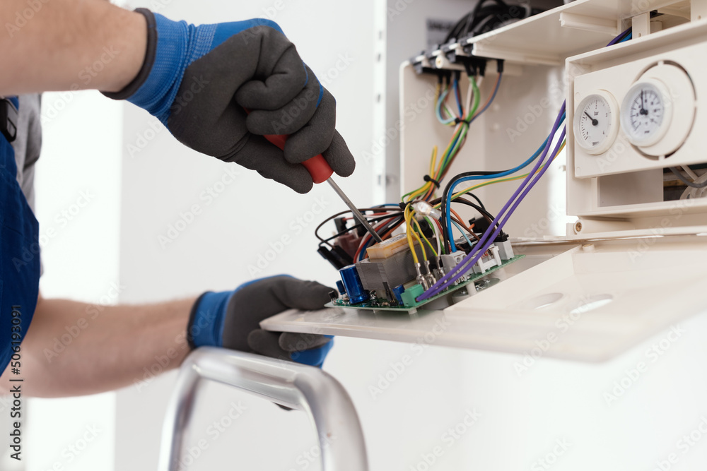 Qualified engineer servicing a boiler Qualified engineer servicing a boiler