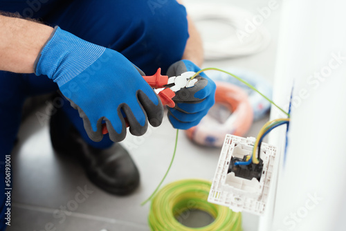 Professional electrician working on the electrical system photo