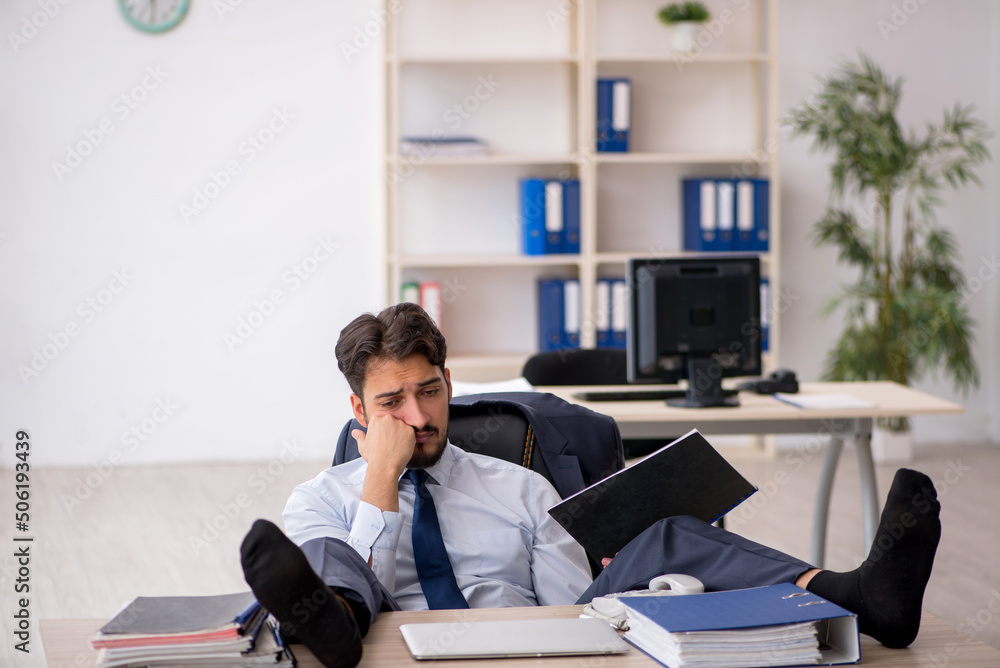 Young male employee working in the office Young male employee working in the office