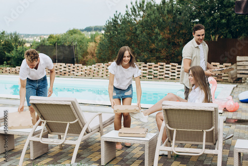 Friends meet by the pool. They ordered pizza, sushi and cocktails.