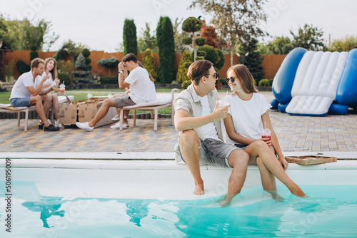 Photography Friends having party near swimming pool,enjoying together.