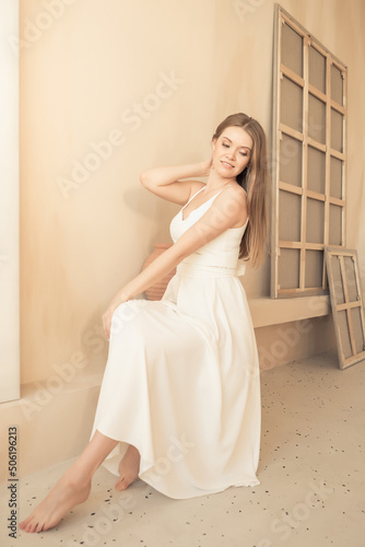 young girl in white dress sits and poses
