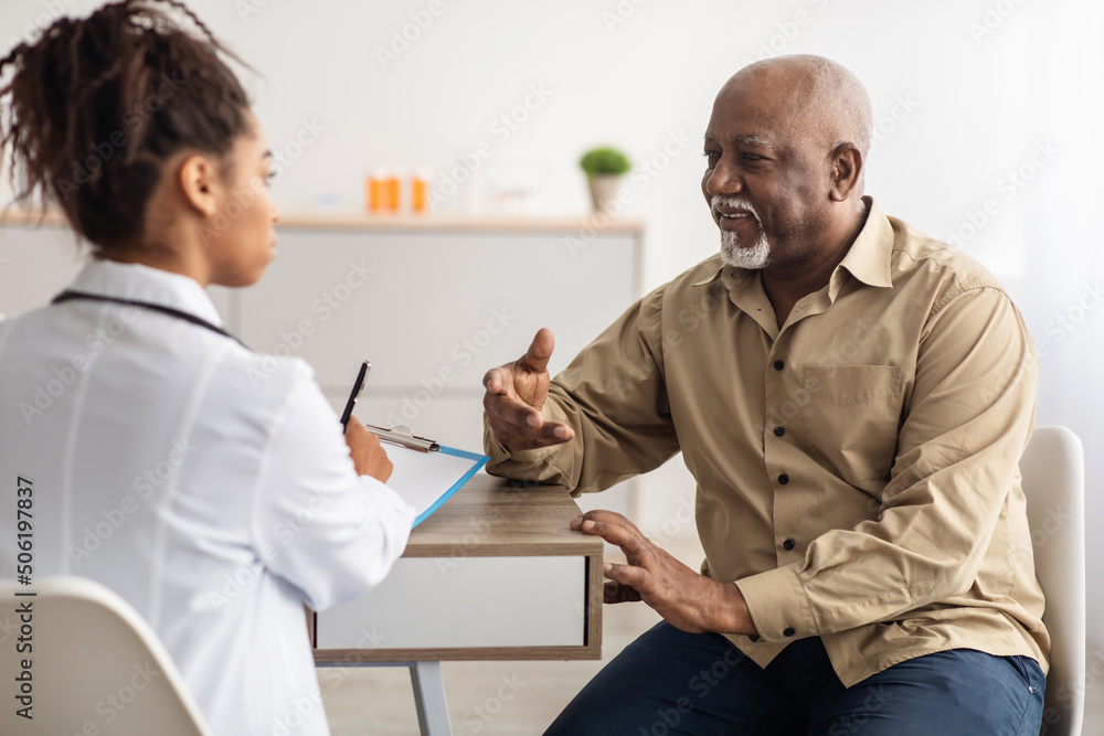 Black patient talking to doctor during appointment - obrazy, fototapety, plakaty 