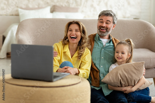 Happy Family Near Laptop Watching Movie Online Sitting At Home