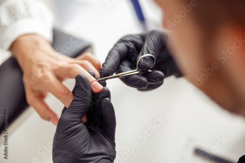 Female client getting treatment manicure procedure in salon