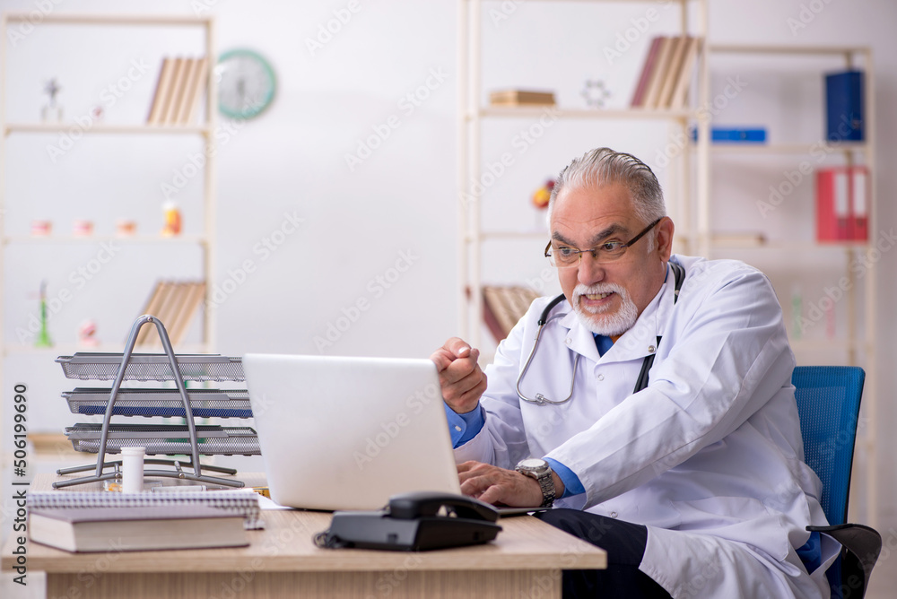 Obraz premium Old male doctor working in the clinic