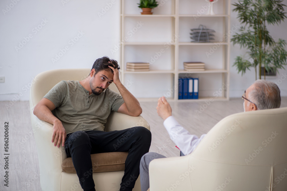 Obraz premium Young man visiting old psychologist