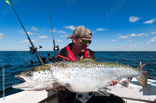 Big salmon fish holding by happy angler