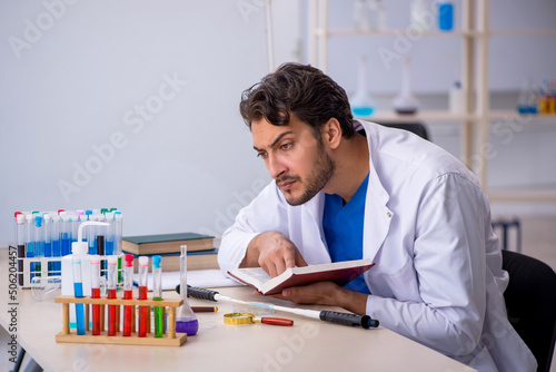 Young male chemist working at the lab