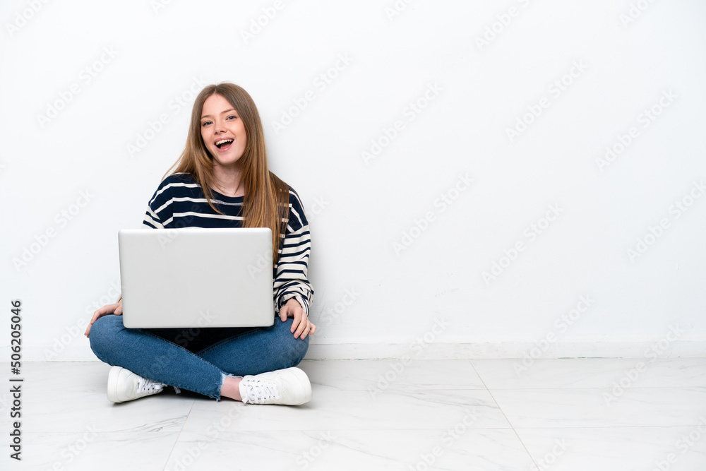 Young caucasian woman with a laptop sitting on the floor isolated on white background with surprise facial expression Young caucasian woman with a laptop sitting on the floor isolated on white background with surprise facial expression