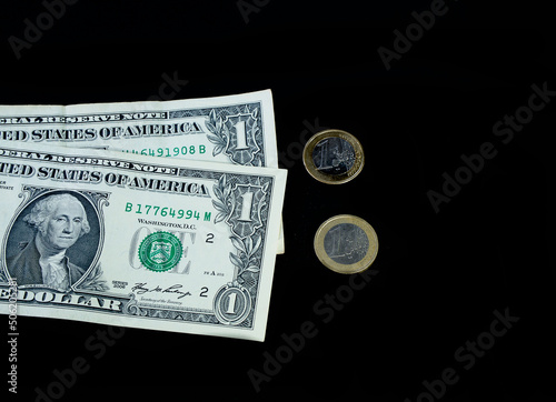 Two dollars at one denomination and 2 euros at one denomination on a black background © Mariyka LnT