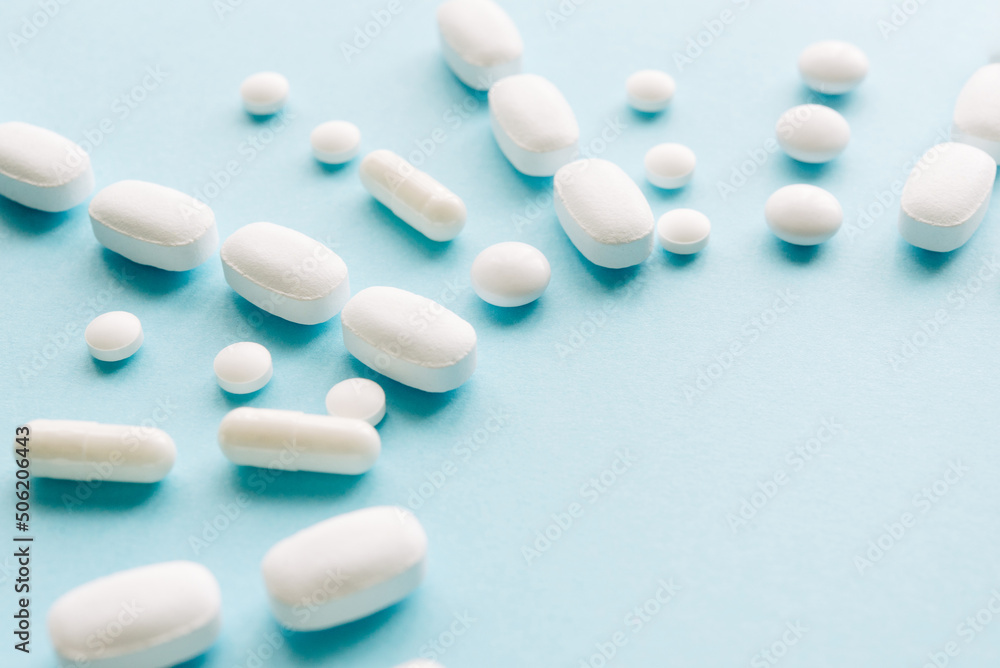 White pills on a pastel background. Capsules and round pills close-up. Healthcare and medicine. White pills on a pastel background. Capsules and round pills close-up. Healthcare and medicine.