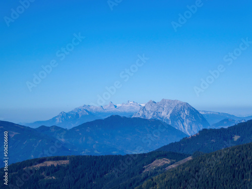 A panoramic view on a massive, stony Alps from Kaiserau Kreuzkogel region in Austria. There are endless mountains chains in the back. The slopes are overgrown with moss and grass. Sunny and bright day © Chris