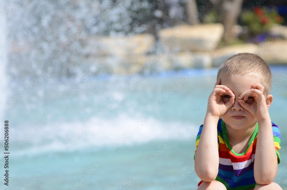 Cheerful boy portrait by the pool. The child having fun. Concept: summer family vacation, childhood, joy. Space for text Aquapark. Water park. Cheerful boy portrait by the pool. The child having fun. Concept: summer family vacation, childhood, joy. Space for text Aquapark. Water park.