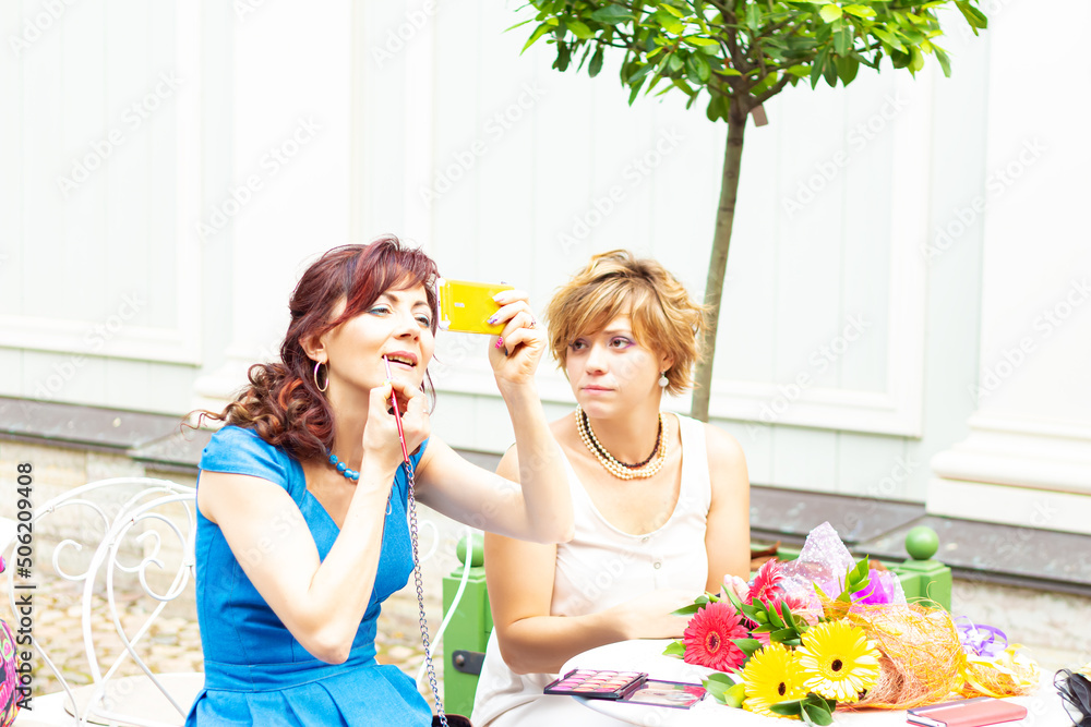 Two women met in a summer cafe. Two women met in a summer cafe.