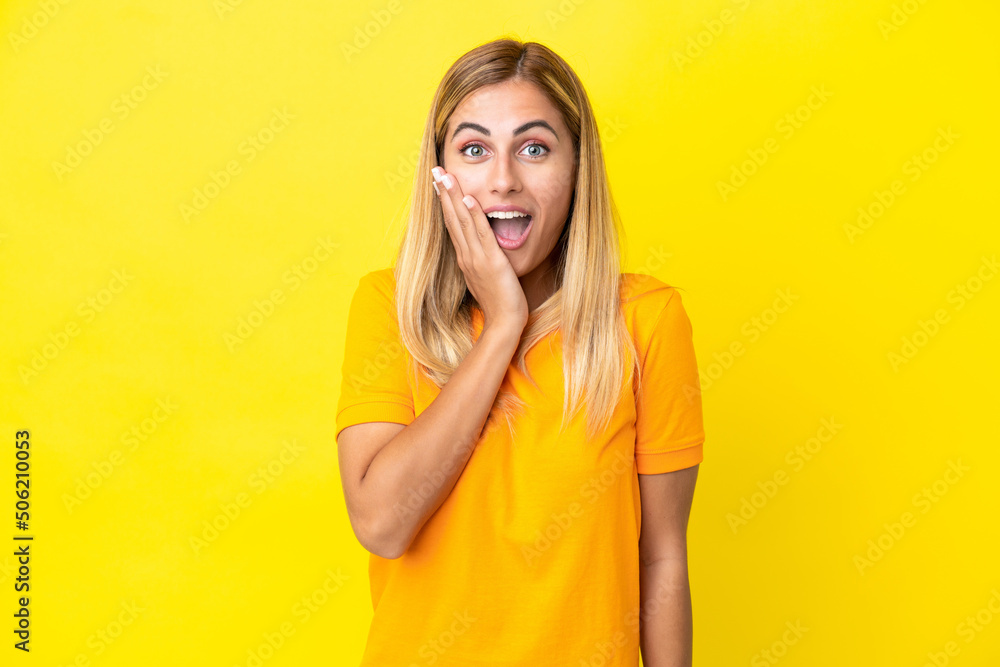 Blonde Uruguayan girl isolated on yellow background with surprise and shocked facial expression Blonde Uruguayan girl isolated on yellow background with surprise and shocked facial expression