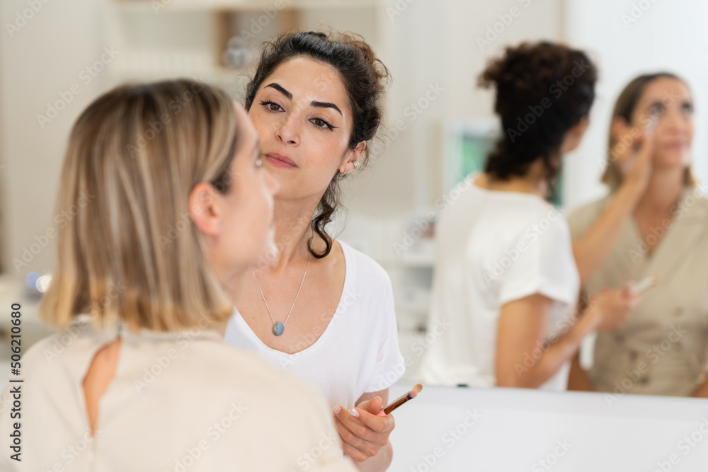 Arab makeup artist making up a woman in a beauty center. Arab makeup artist making up a woman in a beauty center.