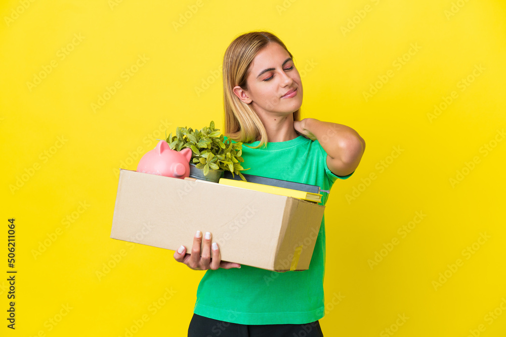 Young Uruguayan girl making a move while picking up a box full of things isolated on yellow background suffering from pain in shoulder for having made an effort Young Uruguayan girl making a move while picking up a box full of things isolated on yellow background suffering from pain in shoulder for having made an effort