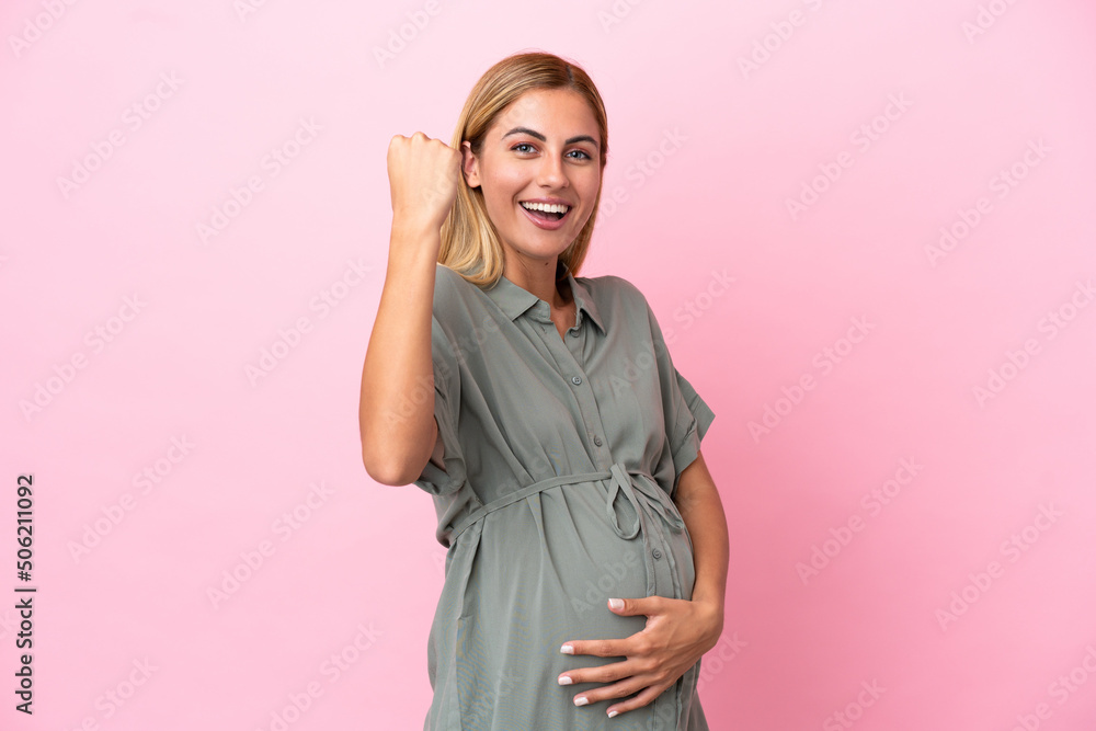 Young Uruguayan woman isolated on blue background pregnant and celebration a victory Young Uruguayan woman isolated on blue background pregnant and celebration a victory