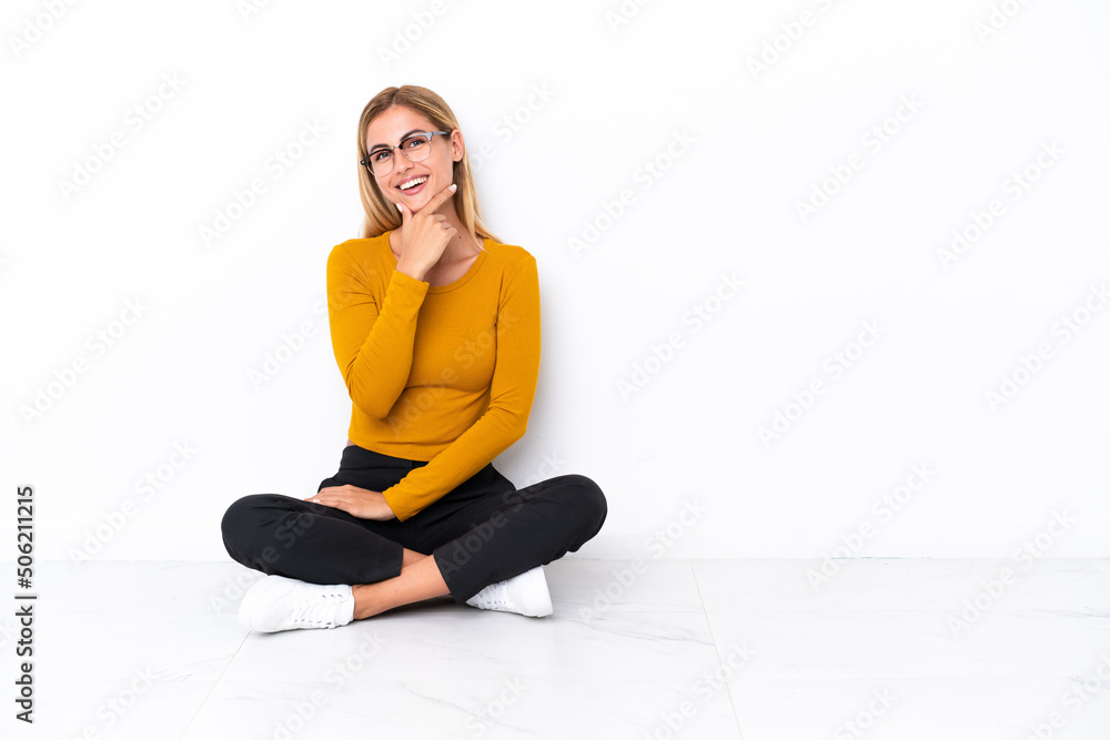 Blonde Uruguayan girl sitting on the floor with glasses and smiling Blonde Uruguayan girl sitting on the floor with glasses and smiling