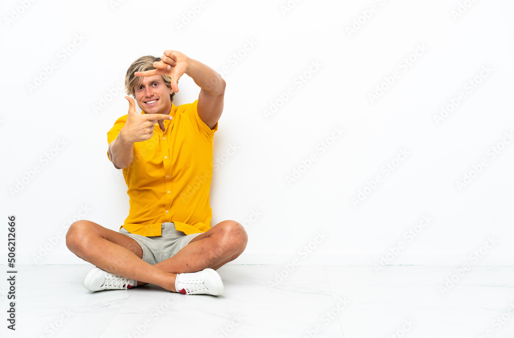 Young English man sitting on the floor focusing face. Framing symbol Young English man sitting on the floor focusing face. Framing symbol