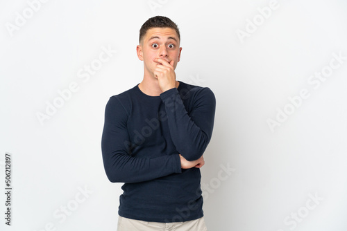 Young caucasian man isolated on white background surprised and shocked while looking right