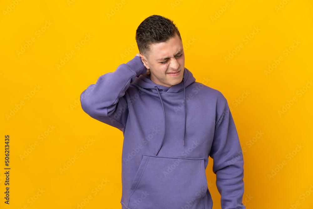 Young caucasian man isolated on yellow background with neckache Young caucasian man isolated on yellow background with neckache