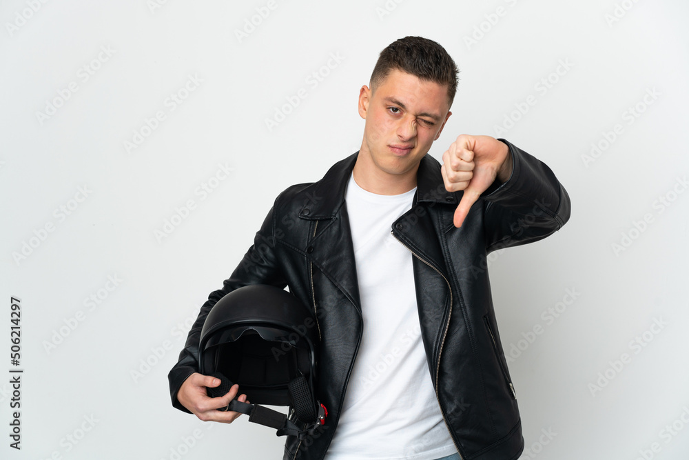 Fototapeta premium Caucasian man with a motorcycle helmet isolated on white background showing thumb down with negative expression