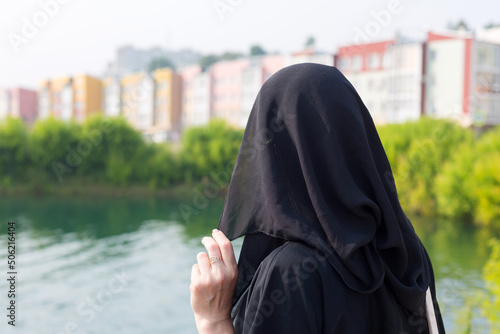 Photography A Muslim woman in a black outfit walks through the city covering her face with a burqa
