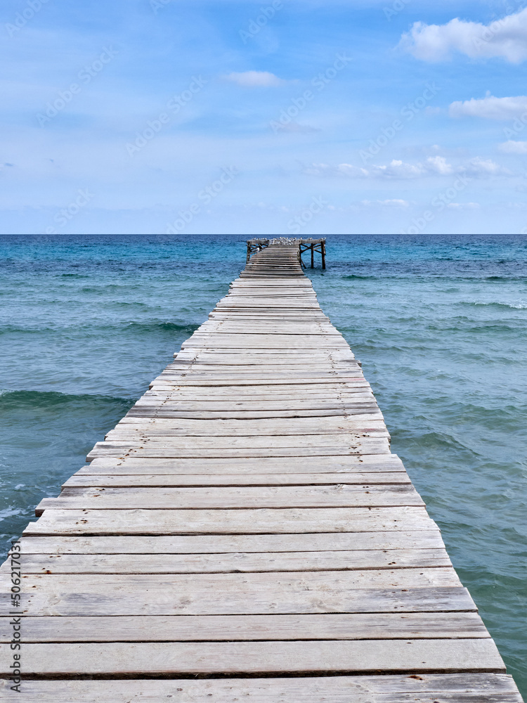Wooden pier in the Mediterranean in Playa de Muro. Muro beach in the Bay of Alcudia, Majorca, Balearic Islands, Spain