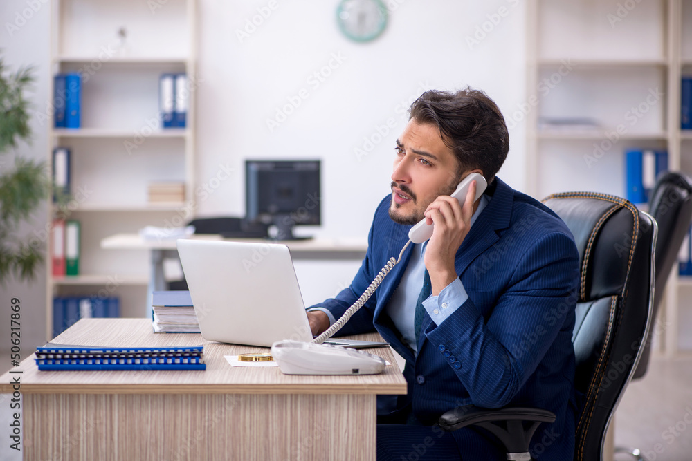 Young male employee working in the office Young male employee working in the office