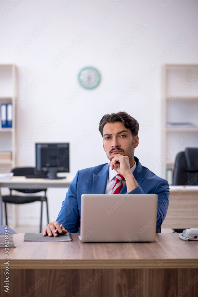 Young male employee working in the office Young male employee working in the office
